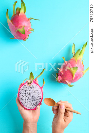 Dragon fruit or pitaya holding by woman hand with spoon for eating on color background Dragon fruit or pitaya holding by woman hand with spoon for eating on color background 79750719