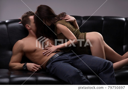 Man and woman hide faces during sexual games on black sofa Man and woman hide faces during sexual games on black sofa 79750897