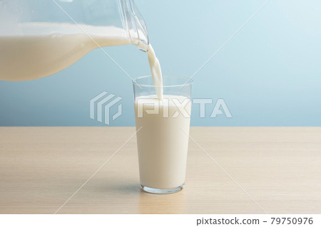 Pour milk into the glass Pour milk into the glass 79750976