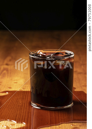 Iced coffee overflowing from a glass 79751008