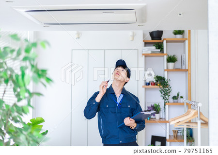 A man in work clothes inspecting a house 79751165