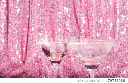 Martini cocktail background pink shiny curtain. Alcoholic classic drink with ice in elegant glass for the celebration Martini cocktail background pink shiny curtain. Alcoholic classic drink with ice in elegant glass for the celebration 79753086