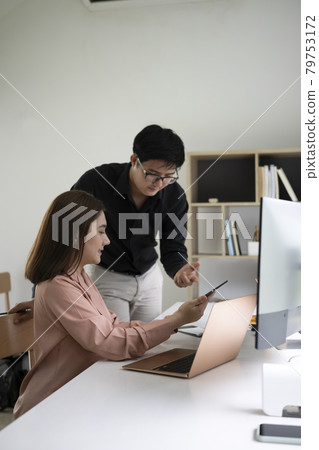 Two young business people discussing business idea in modern office. Two young business people discussing business idea in modern office. 79753172