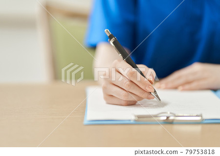 Caregiver's hand to fill out the form 79753818