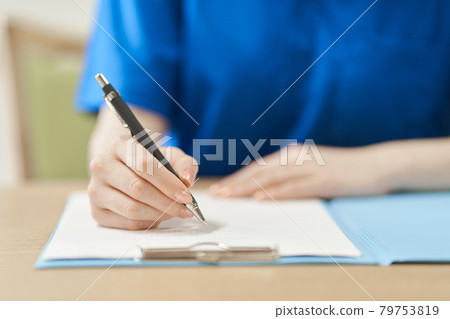 Caregiver's hand to fill out the form 79753819