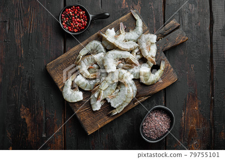 Black raw tiger shrimps, on wooden cutting board, on old dark wooden table , top view flat lay Black raw tiger shrimps, on wooden cutting board, on old dark wooden table , top view flat lay 79755101