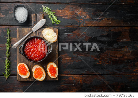 Canape with Red Salmon Caviar for New Year, on old dark wooden table background, top view flat lay with copy space for text 79755163