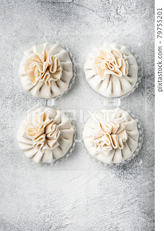 Uncooked Baozi chinese dumplings. Azian dumplings, in plastic tray, on gray stone background, top view flat lay, with copy space for text Uncooked Baozi chinese dumplings. Azian dumplings, in plastic tray, on gray stone background, top view flat lay, with copy space for text 79755201