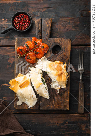 Stuffed chicken meat with filo, with baked cherry tomatoes, on serving board, on old dark wooden table background, top view flat lay Stuffed chicken meat with filo, with baked cherry tomatoes, on serving board, on old dark wooden table background, top view flat lay 79755218