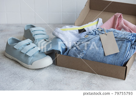Clothes fir kids in an open cardboard box 79755793