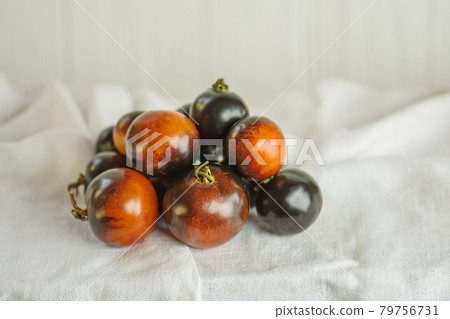 Tomatoes Indigo rose on a white surface. Tomatoes Indigo rose on a white surface. 79756731