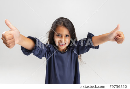 Close up portrait of one cute smiling preschool girl in beautiful dress isolated over white studio background. 79756830