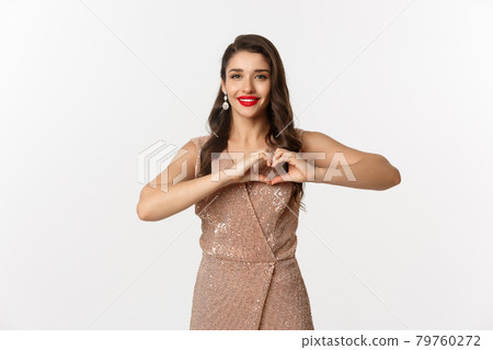 Celebration and party concept. Beautiful young woman in elegant dress showing heart sign, I love you gesture, express sympathy and smiling, white background 79760272