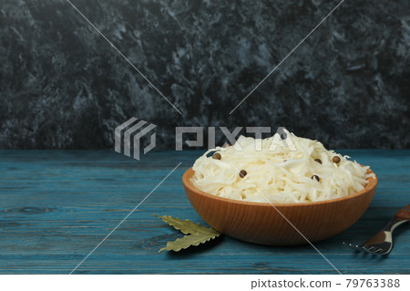 Wooden bowl with sauerkraut and fork on wooden table 79763388