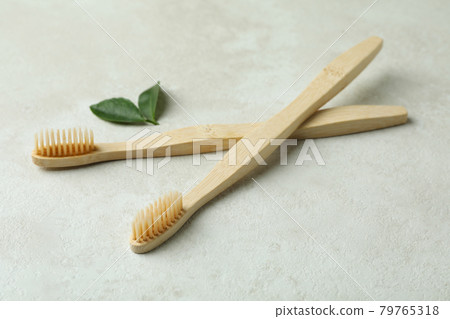 Eco friendly toothbrushes and leaves on white textured background Eco friendly toothbrushes and leaves on white textured background 79765318