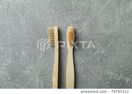 Eco friendly wooden toothbrushes on gray background Eco friendly wooden toothbrushes on gray background 79765322