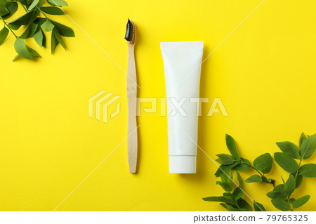 Eco friendly toothbrush, toothpaste and branches on yellow background Eco friendly toothbrush, toothpaste and branches on yellow background 79765325