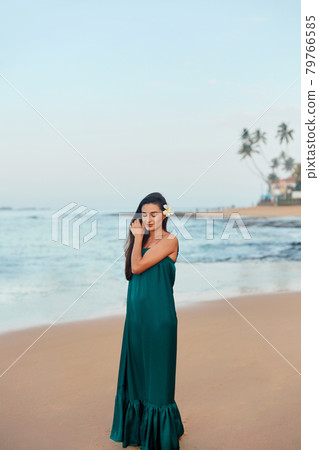 Portrait of beautiful young woman in dress on the beach. Pretty girl on tropical beach. Freedom concept, holiday, beach, sky background. 79766585