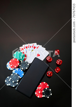 Casino chips, playing cards, dices and mobile phone on dark reflective background 79767433
