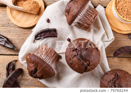 Chocolate carob cupcakes with carob pods and carob powder Chocolate carob cupcakes with carob pods and carob powder 79768244
