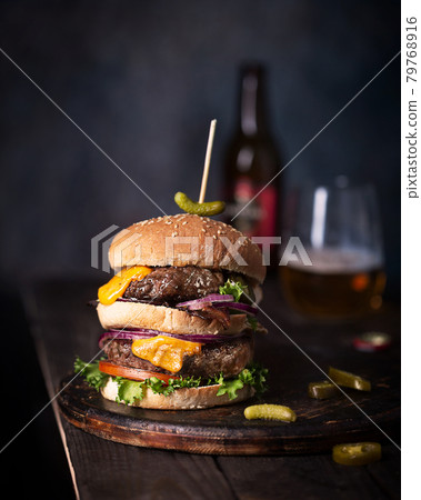 Home made burgers with two cutlets and beer, french fries on a table Home made burgers with two cutlets and beer, french fries on a table 79768916