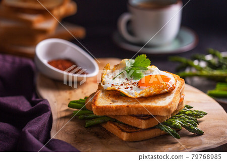 Fresh sandwiches with fried egg served with asparagus, pepper and parsley 79768985