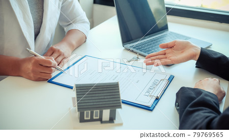 Hand signing on contract after the real estate agent explains the business contract, rent, purchase, mortgage, loan, or home insurance to the buyer. Hand signing on contract after the real estate agent explains the business contract, rent, purchase, mortgage, loan, or home insurance to the buyer. 79769565