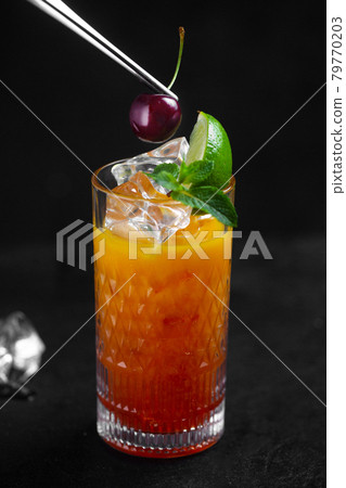 The chef decorates the drink with cherries with tweezers The chef decorates the drink with cherries with tweezers 79770203