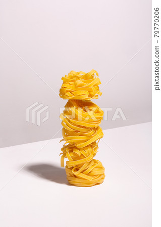 Laid out on top of each other spaghetti nests with a shadow Laid out on top of each other spaghetti nests with a shadow 79770206