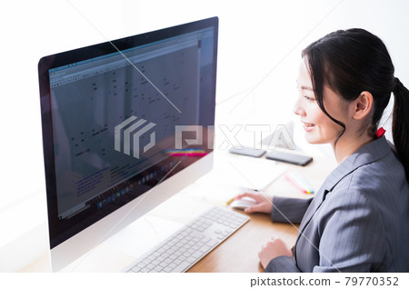 Female engineer working in front of a computer Female engineer working in front of a computer 79770352