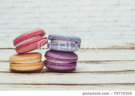 Multicolored macarons on a table and white wall background Multicolored macarons on a table and white wall background 79770509
