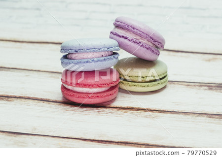 Multicolored macarons on a table and white wall background Multicolored macarons on a table and white wall background 79770529
