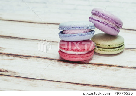 Multicolored macarons on a table and white wall background Multicolored macarons on a table and white wall background 79770530