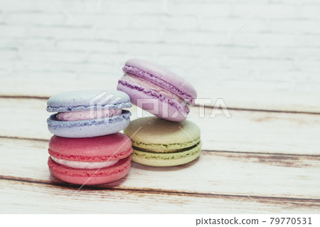 Multicolored macarons on a table and white wall background Multicolored macarons on a table and white wall background 79770531