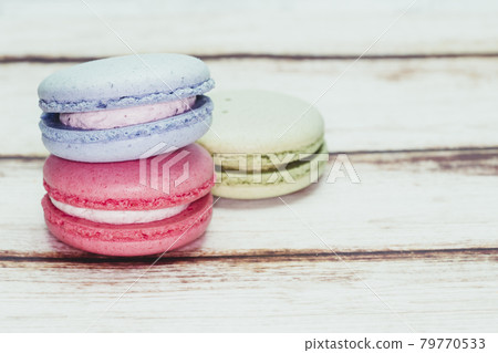 Multicolored macarons on a table and white wall background Multicolored macarons on a table and white wall background 79770533