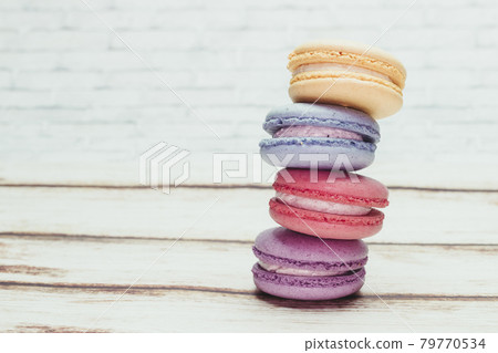 Multicolored macarons on a table and white wall background Multicolored macarons on a table and white wall background 79770534