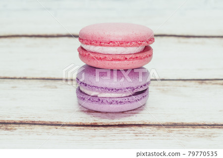 Multicolored macarons on a table and white wall background Multicolored macarons on a table and white wall background 79770535
