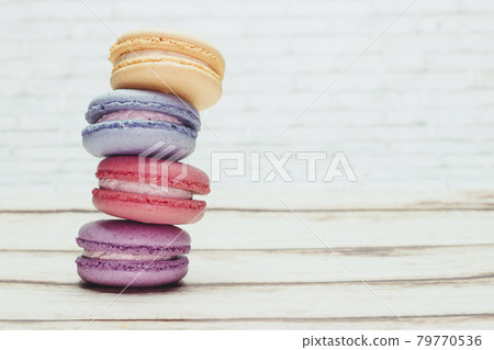 Multicolored macarons on a table and white wall background Multicolored macarons on a table and white wall background 79770536