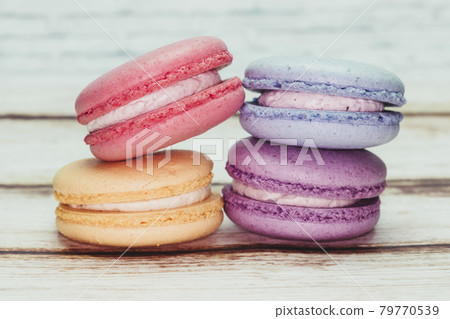 Multicolored macarons on a table and white wall background Multicolored macarons on a table and white wall background 79770539