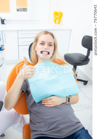 Young beautiful female patient with retractor in dentist office looking at camera 79770645