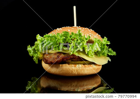 Burger with meat and cheese on black background. 79770994