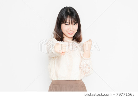 穿著蕾絲襯衫的年輕女子站在白色背景前,做拳頭手勢 穿著蕾絲襯衫的年輕女子站在白色背景前,做拳頭手勢 79771563