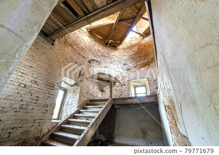Large spacious forsaken empty basement room of ancient building or palace with cracked plastered brick walls, small windows, dirty floor and wooden staircase ladder. Large spacious forsaken empty basement room of ancient building or palace with cracked plastered brick walls, small windows, dirty floor and wooden staircase ladder. 79771679