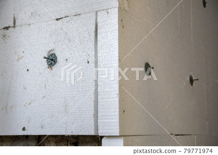 Insulation work of house walls with styrofoam sheets. 79771974