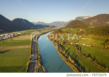 Aerial view of highway interstate road with fast moving traffic near big river in Alps mountains 79772079