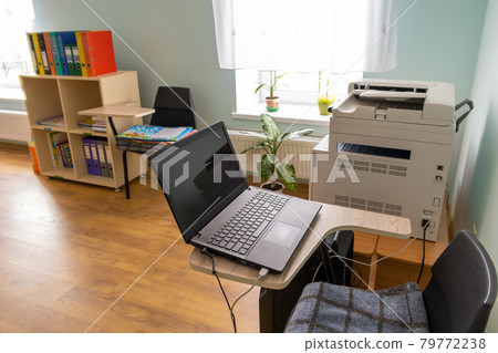 Open black laptop computer on a small chair table in office interior. Open black laptop computer on a small chair table in office interior. 79772238