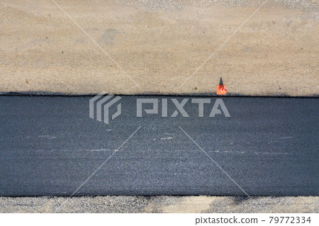 Aerial view of new road construction with newly layed black asphalt lane. Aerial view of new road construction with newly layed black asphalt lane. 79772334