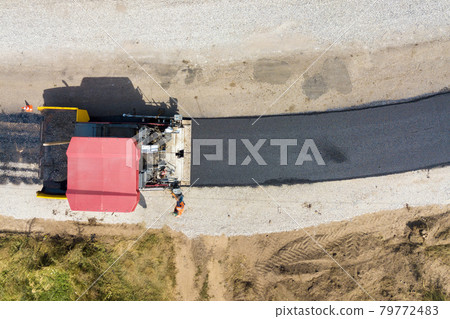 Aerial view of new road construction with asphalt laying machinery at work. 79772483
