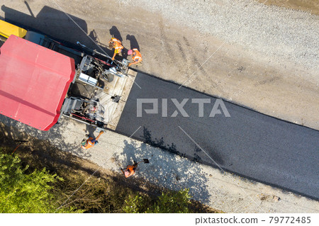 Aerial view of new road construction with asphalt laying machinery at work. 79772485