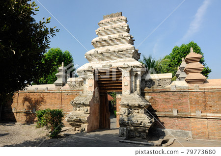 JOGJAKARTA, INDONESIA -JUNE 12, 2014: Entrance arch at old Masjid Besar Mataram Kotagede, Jogjakarta Indonesia. The arch was made from brick and hand made carving stone in traditional Balinese Style JOGJAKARTA, INDONESIA -JUNE 12, 2014: Entrance arch at old Masjid Besar Mataram Kotagede, Jogjakarta Indonesia. The arch was made from brick and hand made carving stone in traditional Balinese Style 79773680